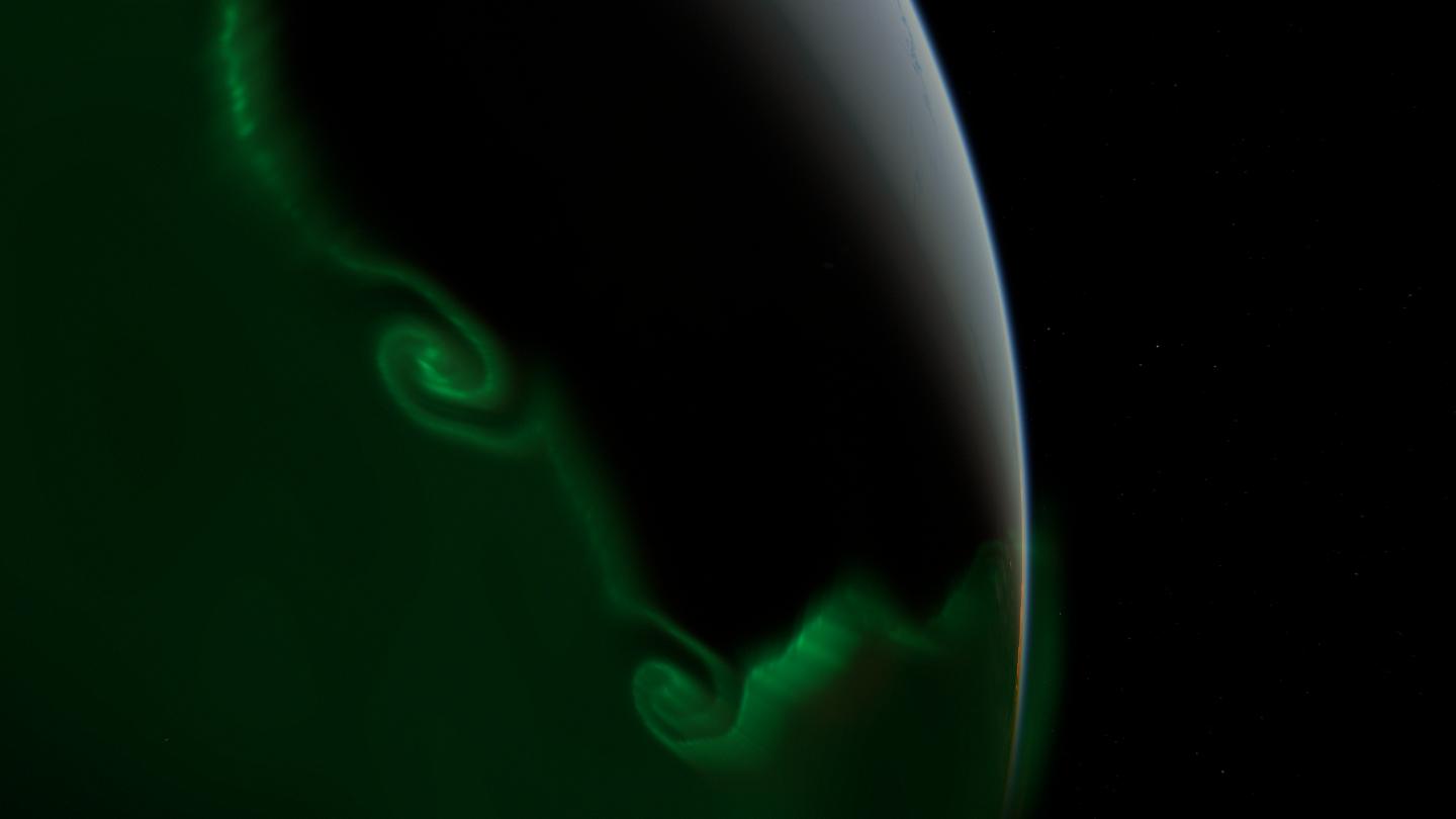 The same view with a broad green glow filling the oval and obvious spirals.