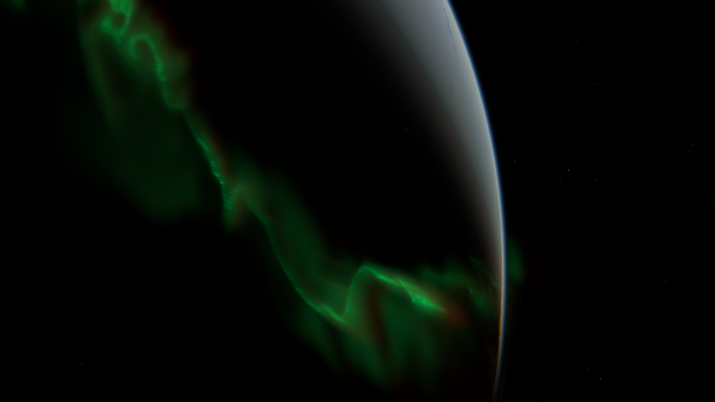 Irregular green folds of varying width over the dark Earth.