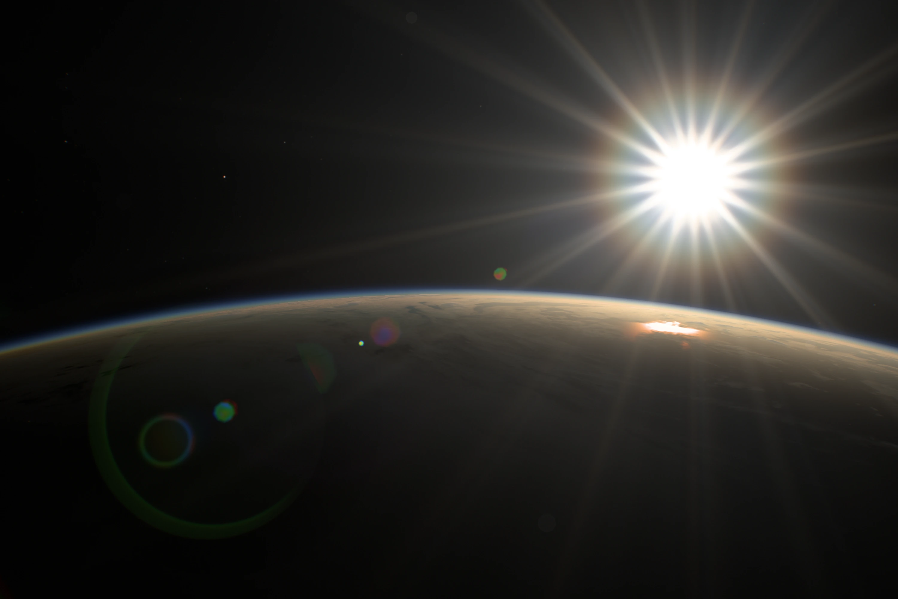 The same frame now: the Sun with long, uneven diffraction rays and only faint ghost rings over the Earth.